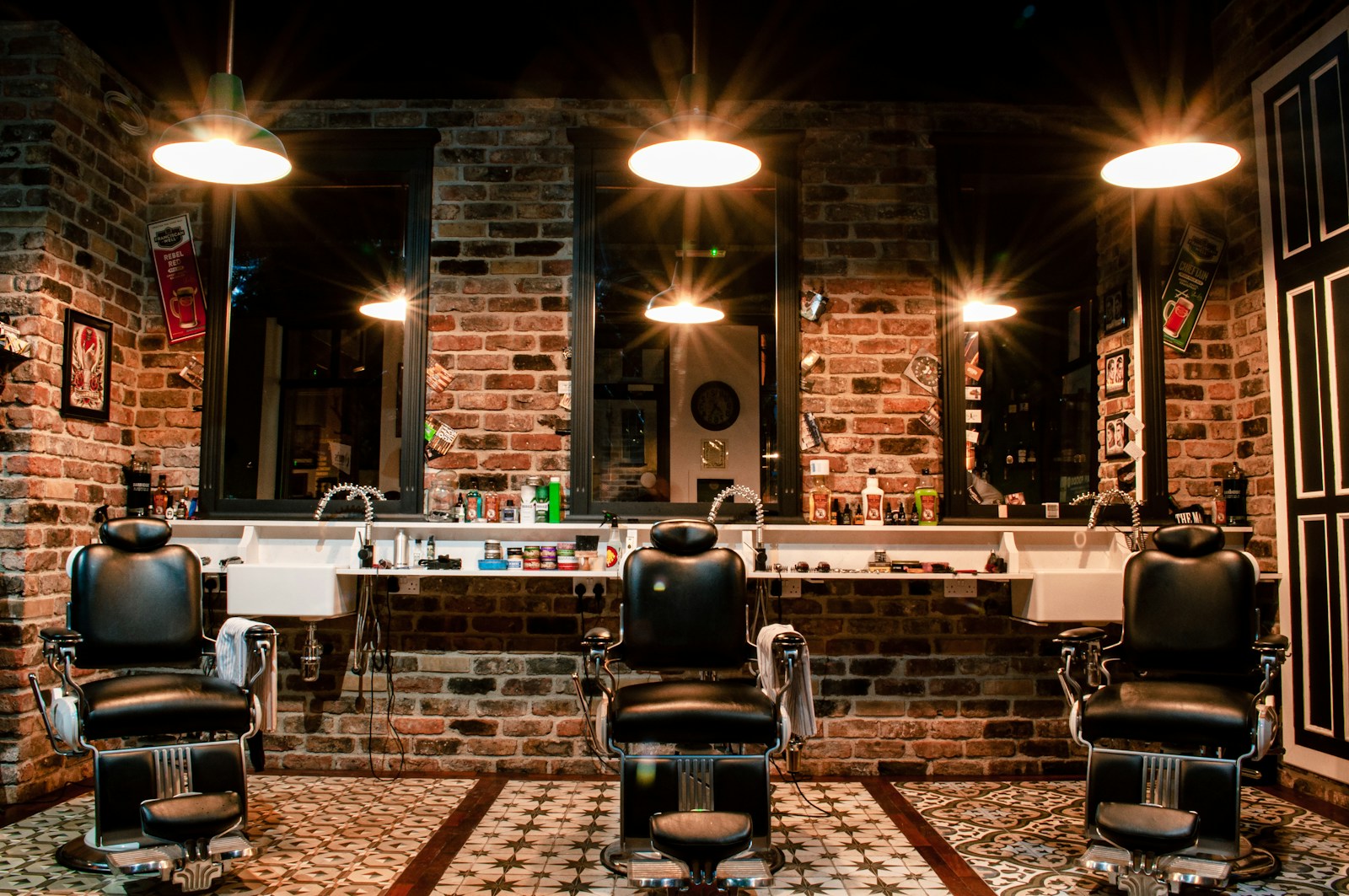 Interior ilustrativo de uma barbearia com cadeiras pretas e parede de tijolos